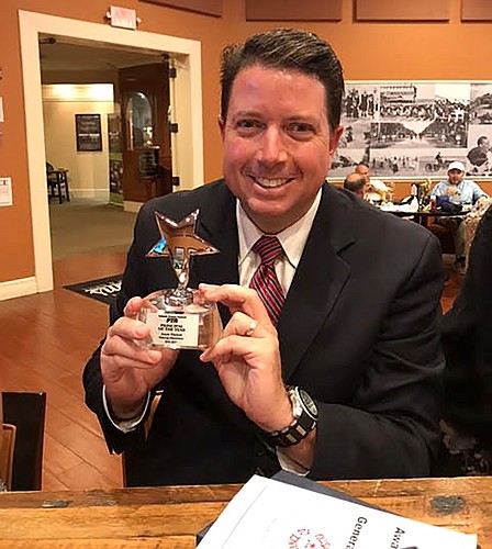 Pathways Elementary Principal Jason Watson proudly shows off his Principal of the Year trophy. Photo courtesy of Pathways Elementary PTA