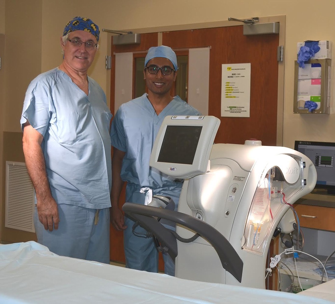 Dr. Ronald Rasmussen and Dr. Shravan Kandula stand with the hospital'       s new technology  (Photo courtesy of Florida Hospital Memorial Medical Center).