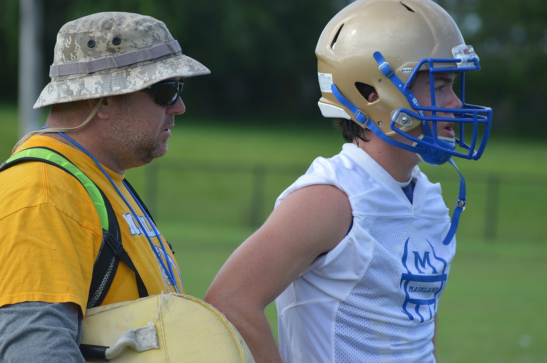 Mainland head coach Scott Wilson (left) and quarterback Jake Novello (right) talk during practice. The senior signal caller has big shoes to fill after Denzel Houston moved on to college. Photo by Tim Briggs