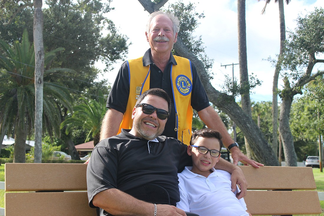 Lion Robert Gettman stands over Sam Rivera and his 10-year-old son, Ashtian, at the small park dedicated to the Ormond Beach Lions Club on N. Beach Street.