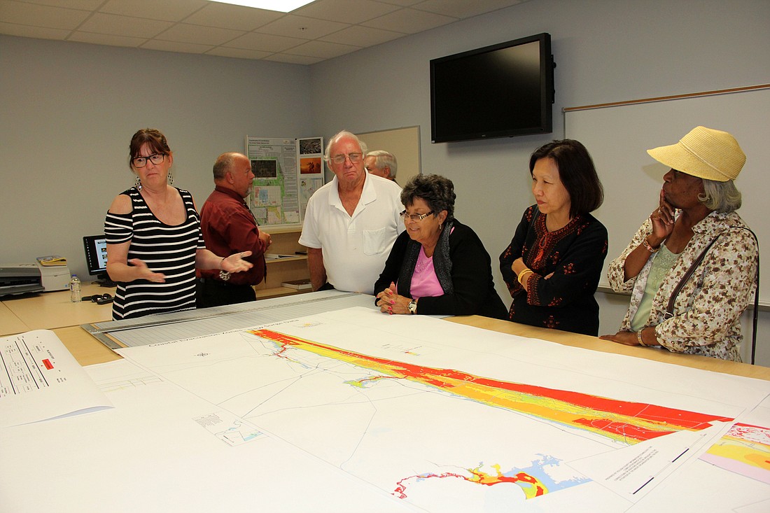 Nancy Church  (left), explains the flood map to Volusia County residents at the emergency operations center tour on Thursday night.  Photo by Jacque Estes