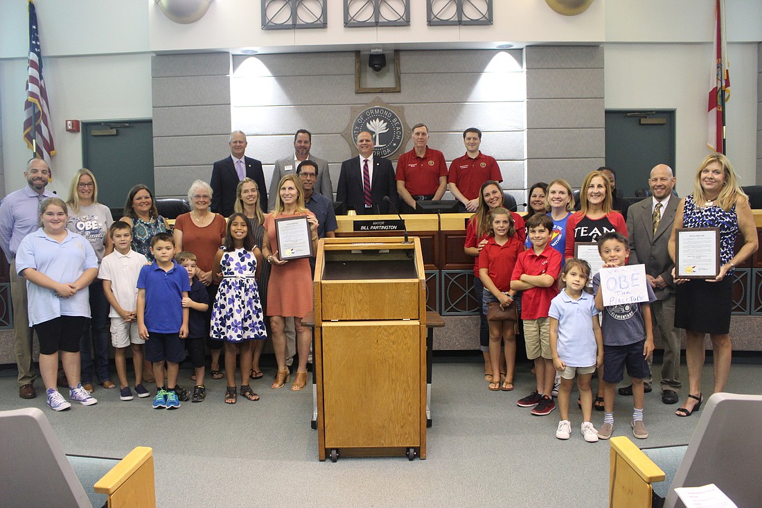 Faculty and students from Ormond beach Elementary, Tomoka Elementary and Pine Trail Elementary hold up their plaques in front of the City Commission during the Sept. 5 meeting. Photo by Jarleene Almenas