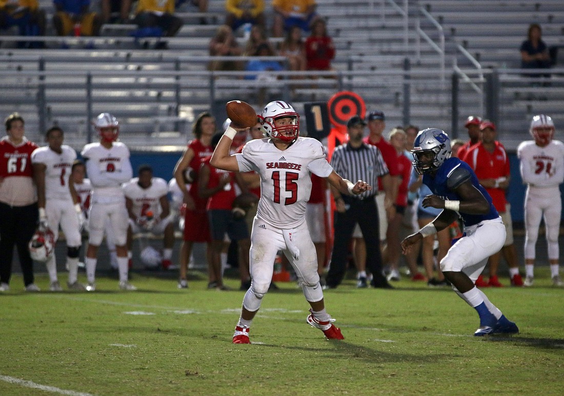 Seabreeze quarterback Jadyn Nirschl throws a pass with a defender coming at him. Photo by Ray Boone