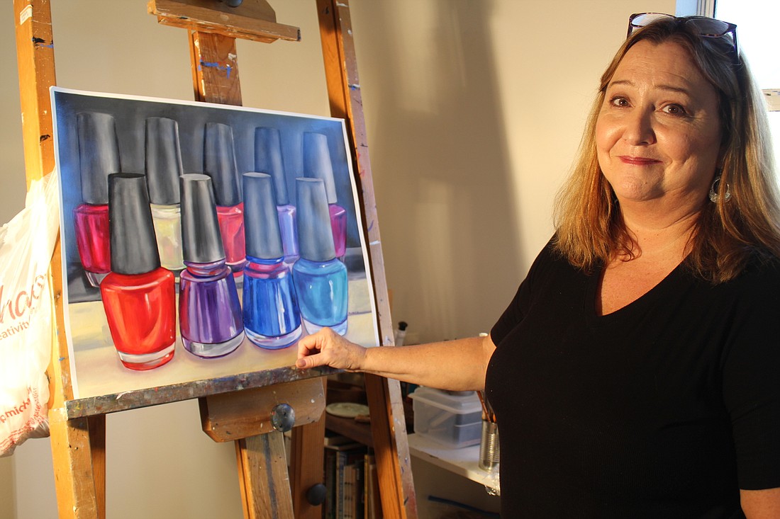 Ormond Beach artist Marilyn Groch stands besides a still life of nail polish bottles at her studio in her home. Photo by Jarleene Almenas
