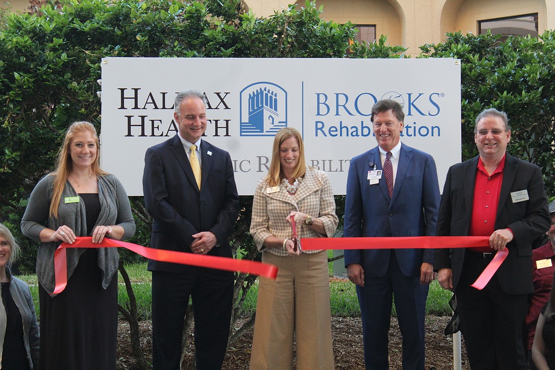 Halifax Health CEO Jeff Feasel, Easterseals CEO Bev Johnson and Brooks Rehabilitation CEO Doug Baer cut the ceremonial ribbon to the hospital's new pediatric rehabilitation therapy clinic on Thursday, Nov. 30. Photo by Jarleene
