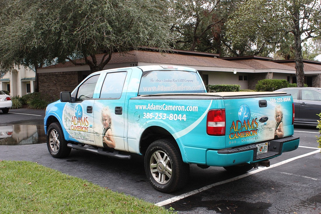 A truck painted with Adams, Cameron and Co. logo sits outside the Ormond Beach office. The company will soon open an office in Flagler Country. Photo by Wayne Grant