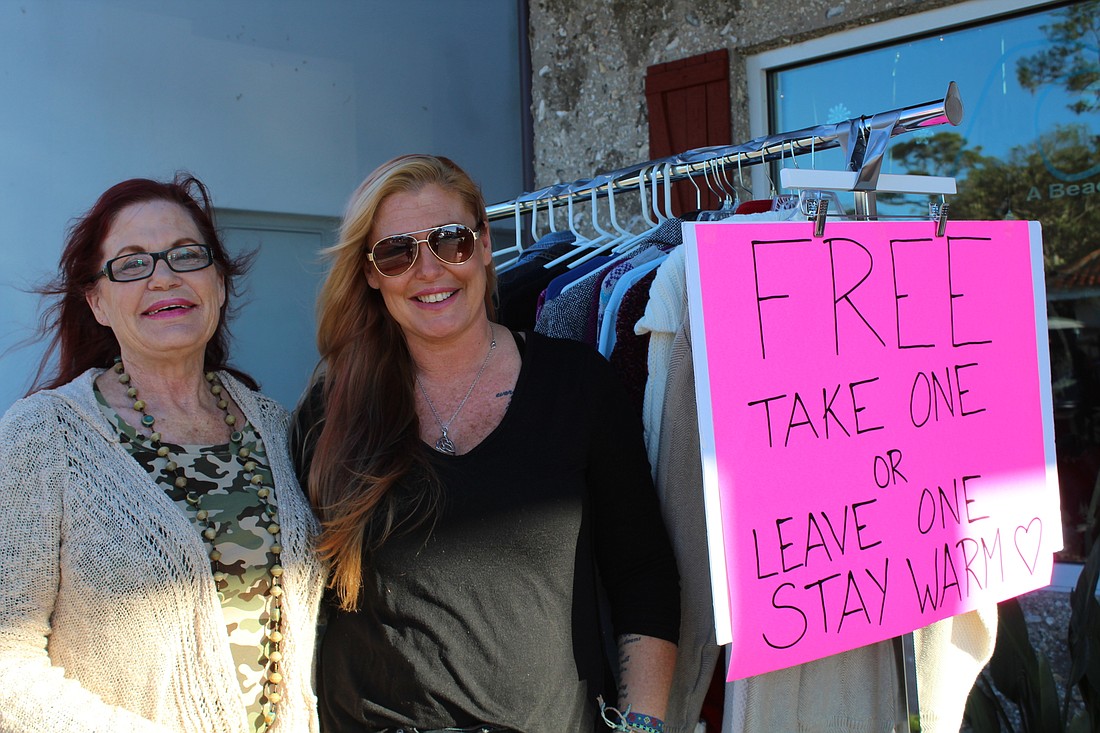 Lyn Hock and Andrea Coleman stand outside Ocean Child beside the free clothing rack. Photo by Jarleene Almenas