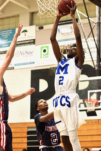 Mainland's Cornelius Smarr dunks a ball against Freedom High School. Photo by Ray Boone