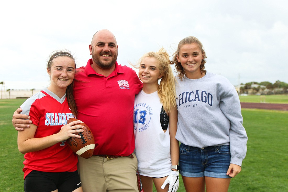 Seabreeze girls flag football head coach Michael Fries stands with players Bailey McQuarrie, Grace Remey and Kara Haas. Photo by Paige Wilson