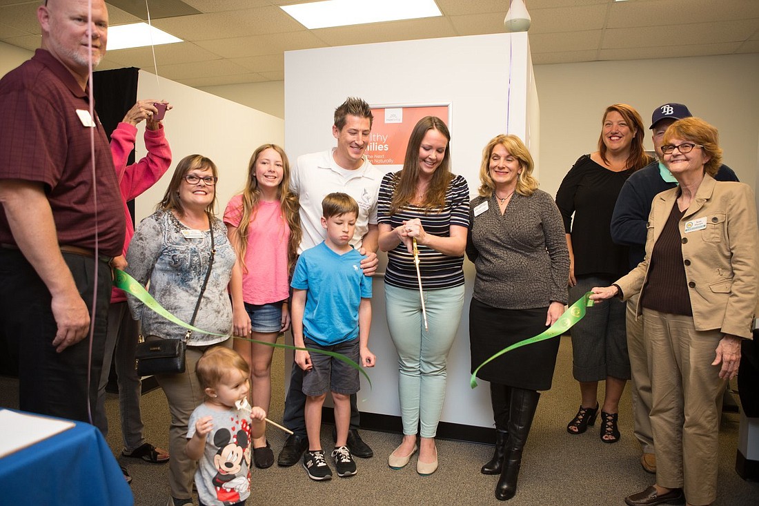 New Journey Chiropractic owners Blake and Jayme Frear (with scissors) are shown at their Chamber of Commerce ribbon cutting. Courtesy photo