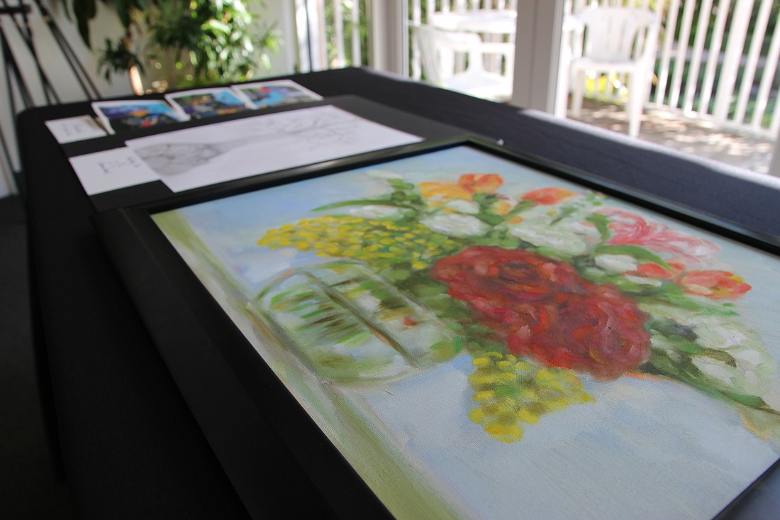 Art by veterans Ming Lei and James "J.J" Jones is laid out on a table at the Ormond Memorial Art Museum before being hung. Photo by Jarleene Almenas