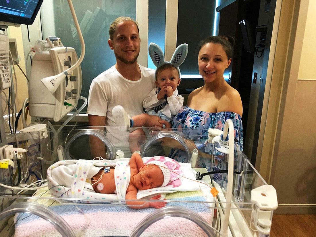 Palm Coast residents Carli and Addison Wieda had to wait five days to hold their new baby for the first time. They are shown with their son and newborn. Courtesy photo
