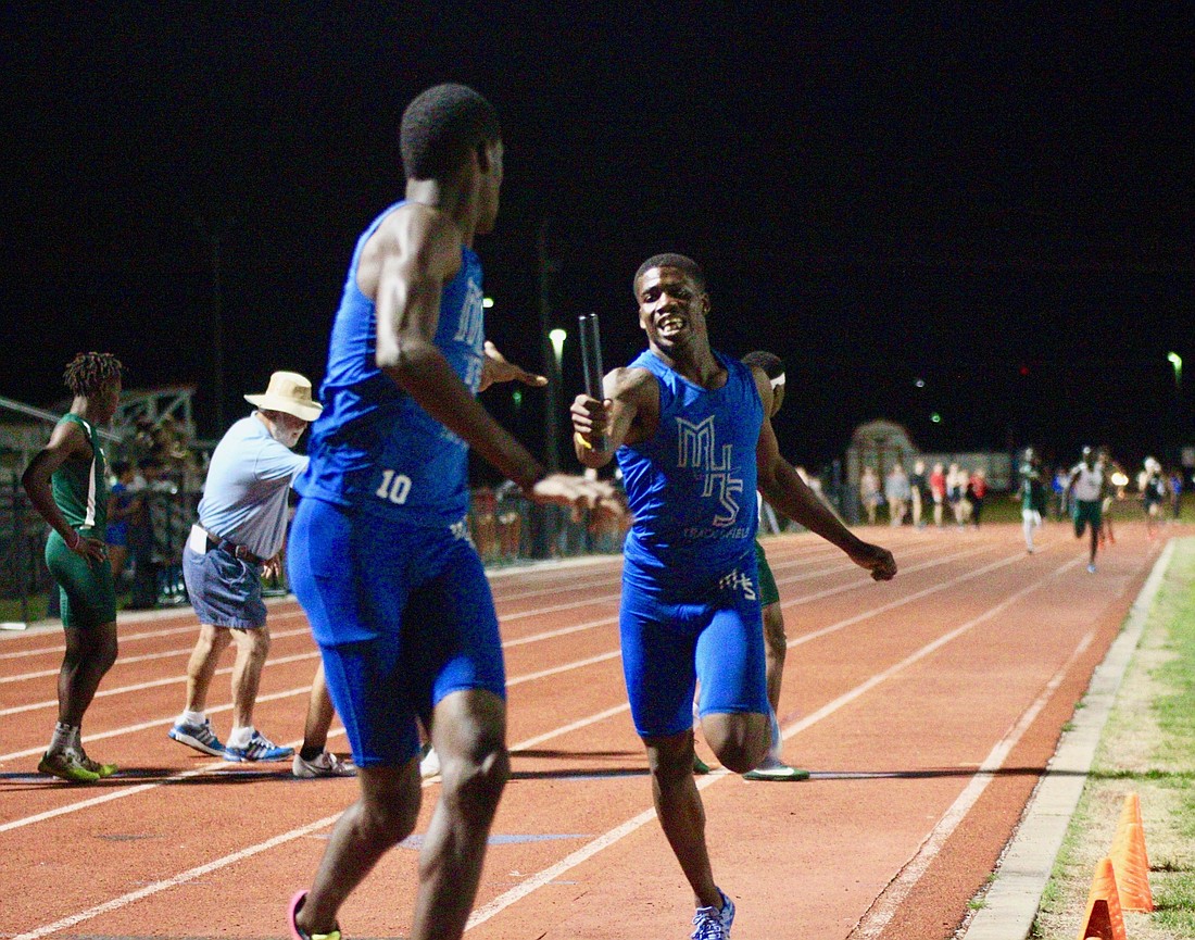 Mainland's Latavies Sylvester hands the baton off to teammate Steffan Mallory. File photo