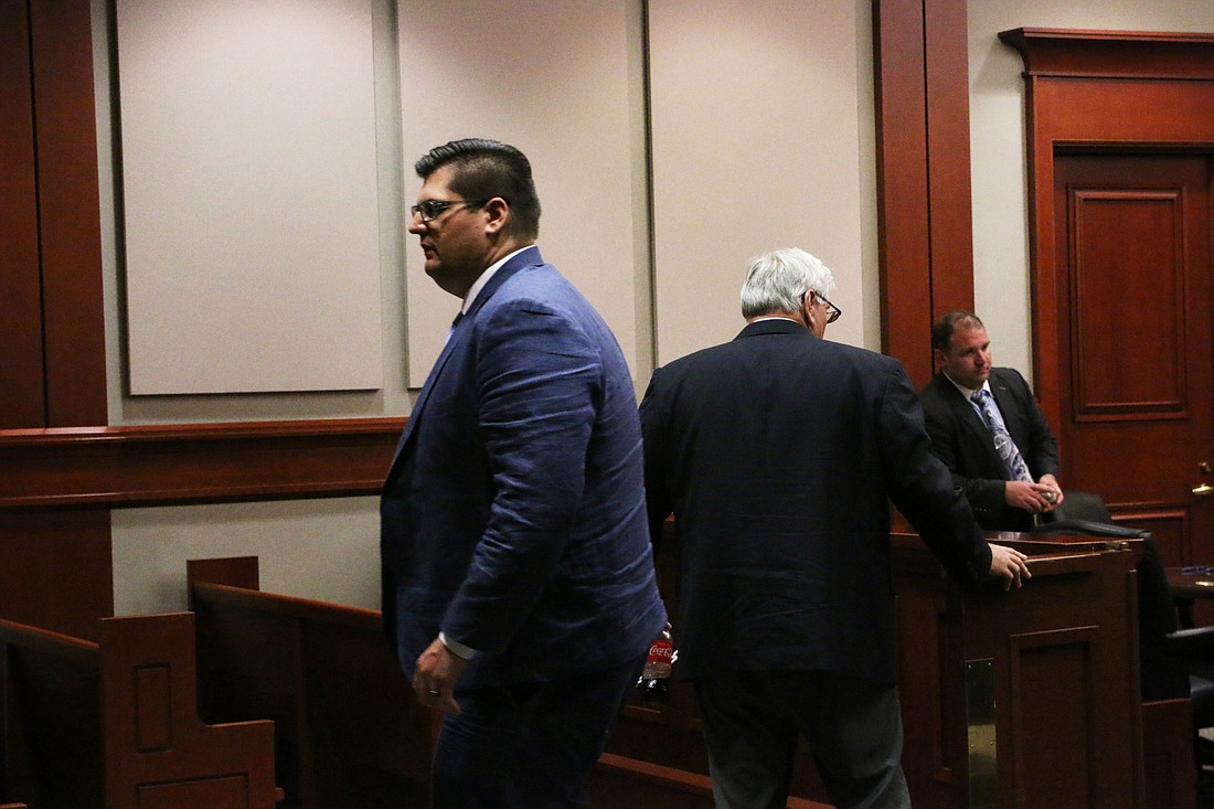 James Holcombe leaves the court chambers on Friday, Aug. 10, as his father, Dale Holcombe, closes the swinging doors behind him. Photo by Jarleene Almenas
