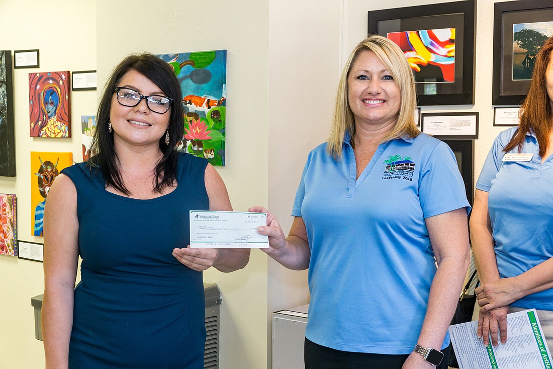 Cameron Vintson receives a check from Olivia Wetherell with the Port Orange Chamber of Commerce for $420. This will be used to provide underprivileged kids scholarships to attend summer camp at ArtHaus. Photo by Zach Fedewa