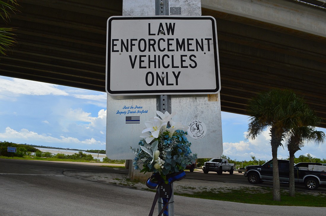 Flowers and a sticker reading "Rest in Peace Deputy Frank Scofield" mark this sign at the Causeway Park boat ramp, which will now be recognized as the Frank Scofield Memorial Boat Ramp. Photo by Caroline Smith