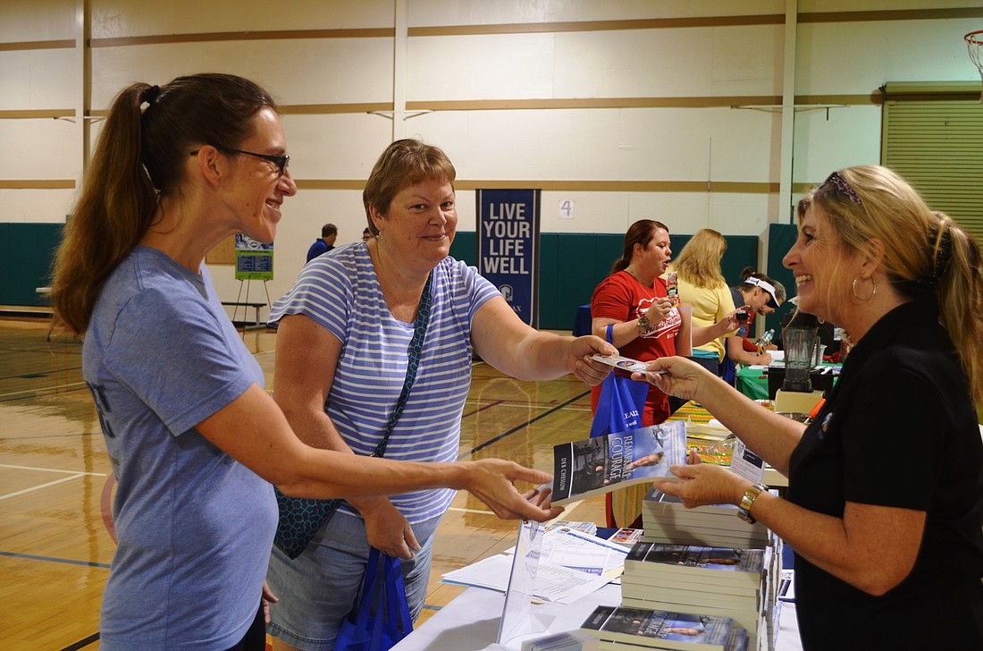 Freddie Smith (right), of Cheslow Achievement Group, talks to Heather Shourdes, of Joy Fitness, and Karen Duffy, who signed up for the Challenge.