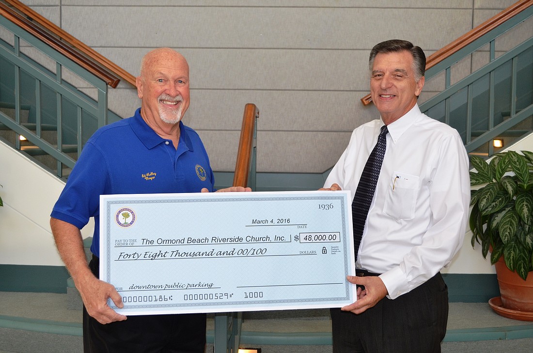 Mayor Ed Kelley presents a check to Pastor Michael Carruthers. Photo by Wayne Grant