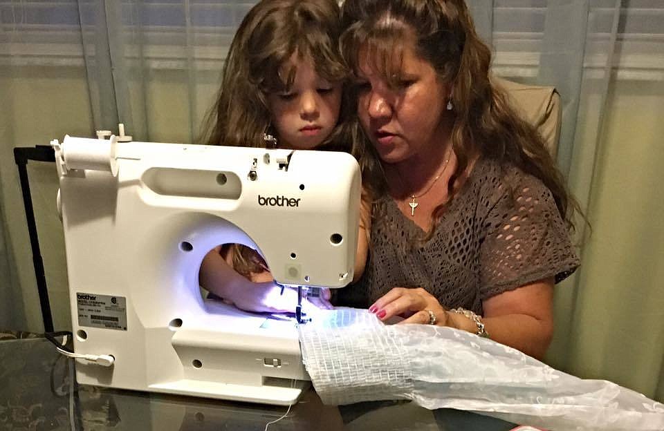 Beth Davis taught her granddaughter, Leah Davis, how to sew a dress for last weekend's Girl Scout competition.