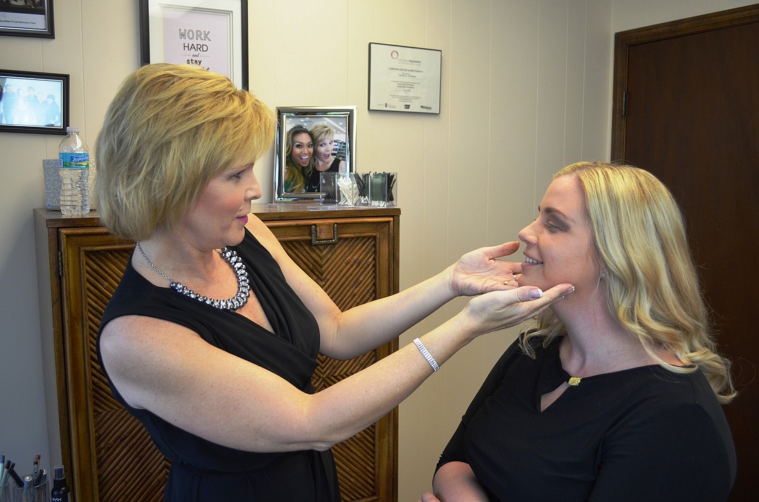 Carole Girman checks the makeup on Nicole Figueroa.Photo by Wayne Grant