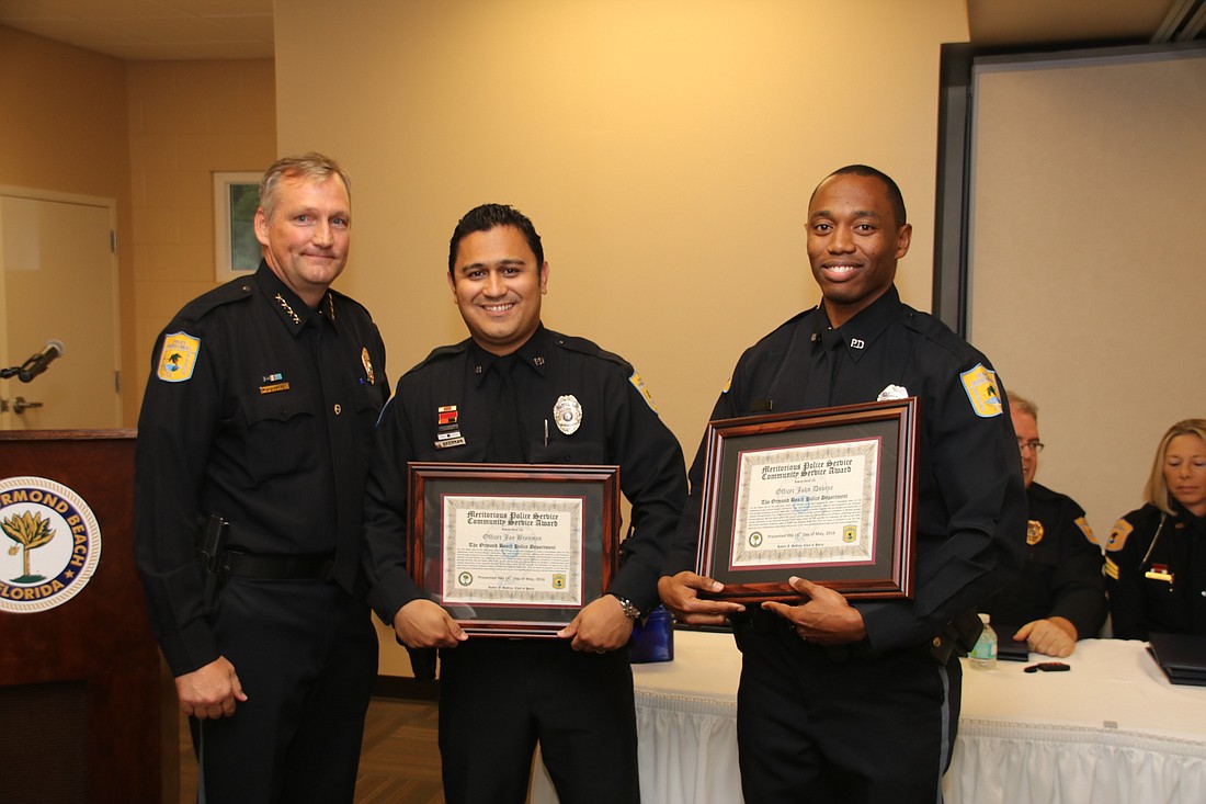 Chief Jesse Godfrey presents awards to Officers Jay Brennan and John Dovine.