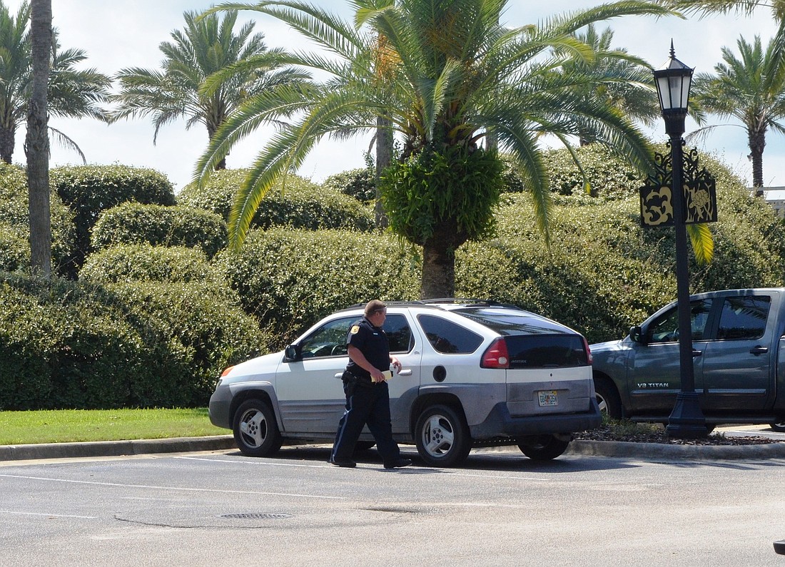 A policeman checks cars at Fortunato Park. If he sees valuables in plain sight, he leaves a warning notice for the owner.