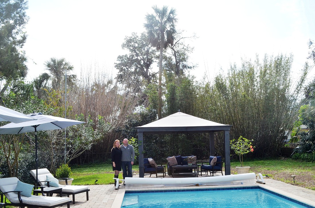 The palm tree behind Ellen and Jonathan Needham at the back property line is about 40-feet tall. A five-story building could be 60-feet tall. A buffer would put the building 60 feet behind the palm tree.