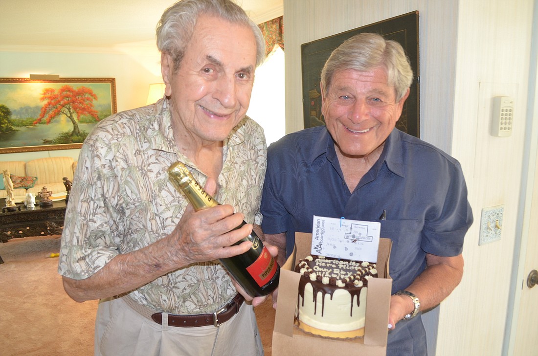 Burt Herman (right) brought a cake and champagne for his reunion with Guy Eby, who he said saved his life.