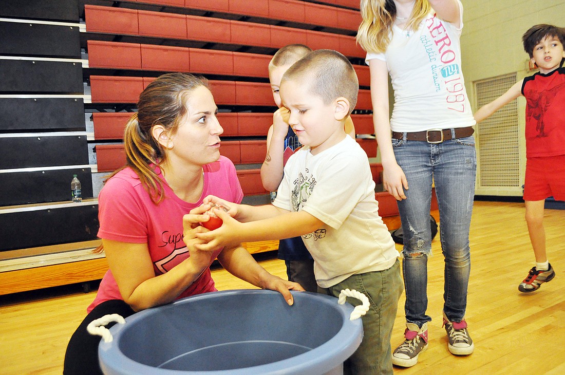 Heather Peugh, of Super Striders, assists Daniel Payne during a food group game. PHOTOS BY SHANNA FORTIER