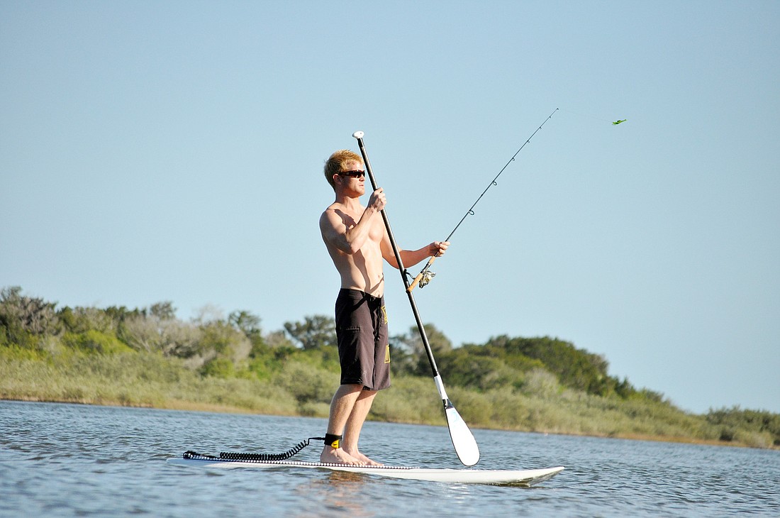 Jordan Farrell fishes from his paddleboard near Flagler Beach.