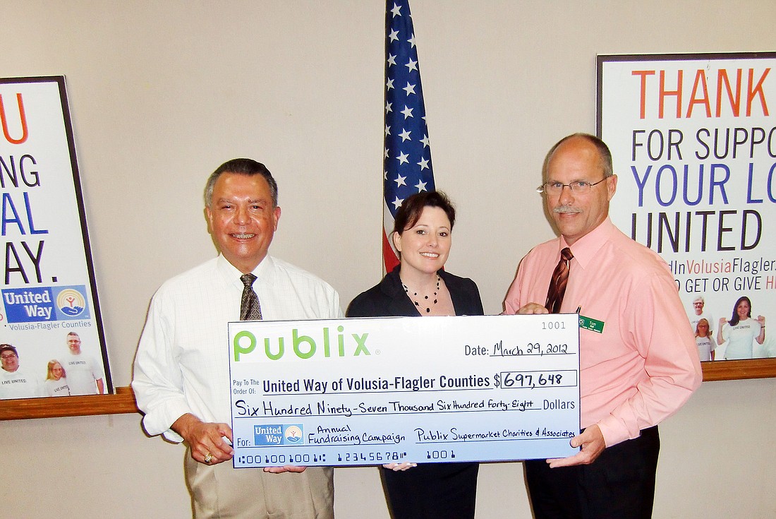 Volusia-Flagler United Way President Ray Salazar and Elan Kaney, board member, accept a $697,648 donation from Tom Sill, of Publix Super Market Charities and associates. COURTESY PHOTO