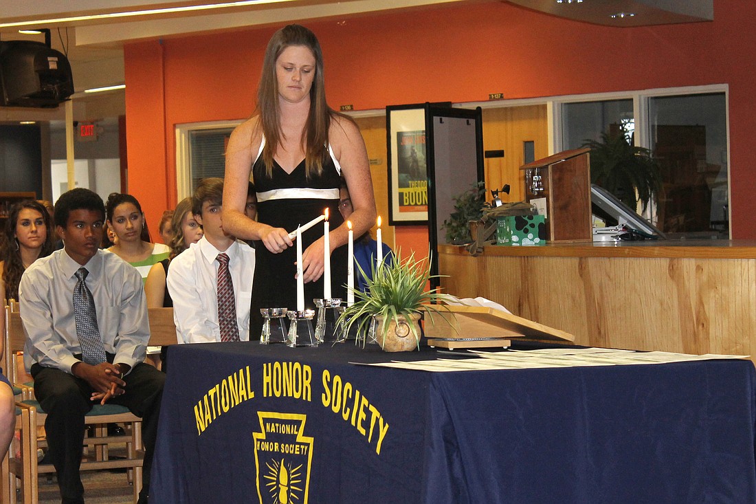 NHS Secretary Kaitlyn Sanson participates in the candle lightening ceremony.
