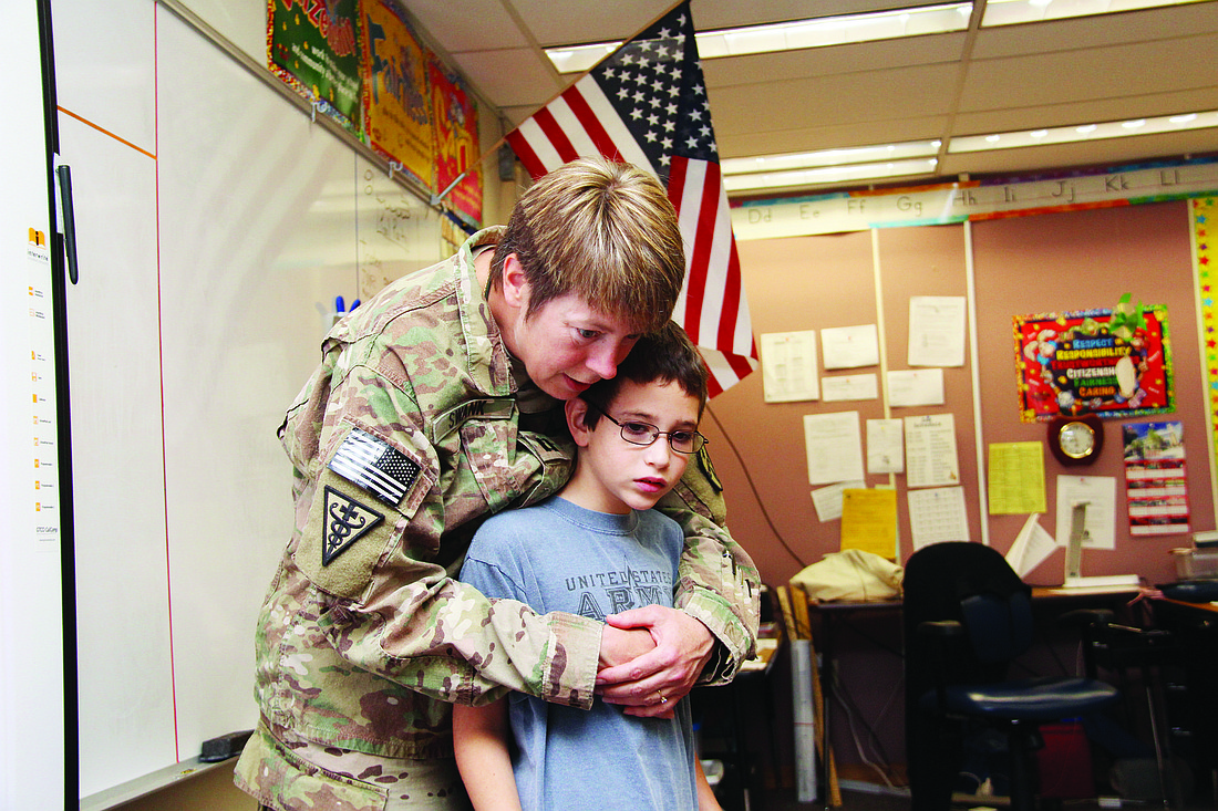 Bruce Collura gets a hug from his aunt, Capt. Teresa Swank, before the rest of his class arrives back to the room for her surprise visit.