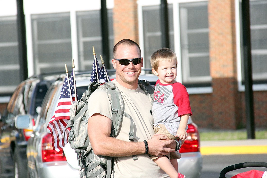 Joe Morris, of the Army National Guard, holds his son, Brennan, before the walk begins.