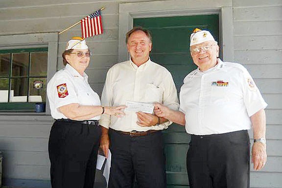 VFW Quartermaster Deidre Wright and Commander Jerry Medearis presents Agricultural Museum Director Bruce Piatek with a check.