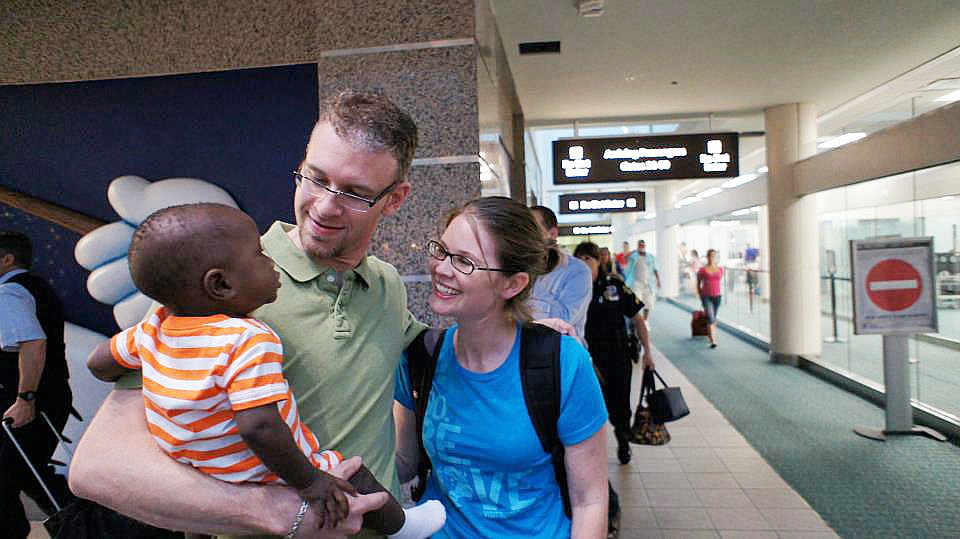 Evan Shows holds his adopted son, Ephrem, for the first time after meeting up with Carla at Orlando International Airport.