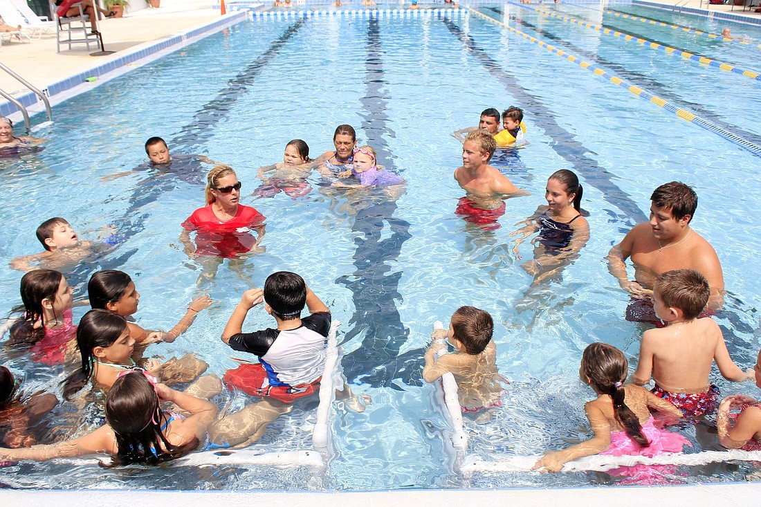 Head swim instructor Mary Ellen Cook gets the children acquainted with the water.