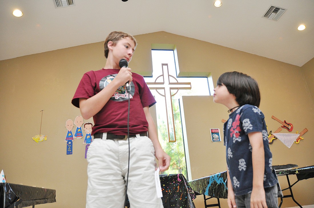 Teen volunteer Christian Norris plays question-and-answer with camper David Ross.