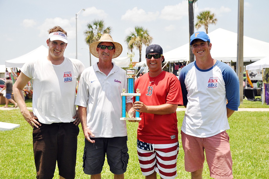 Cornhole tournament champs Tim Allen and Kevin Lewis hold the trophy next to their competitors, Craig Atack (left) and Bob Atack (right).