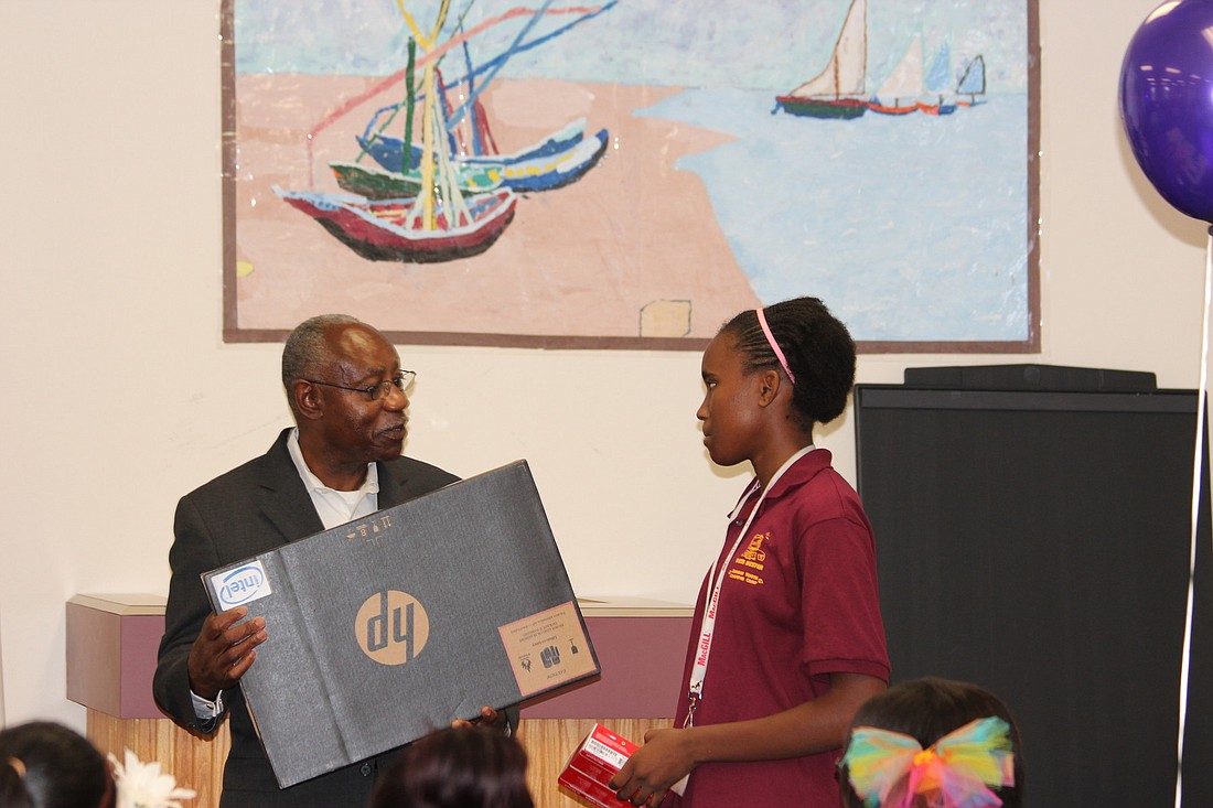 John Edwards, Jr., executive director of NFCAA, awards a laptop to Top Student Runner-up Shanteria Few.