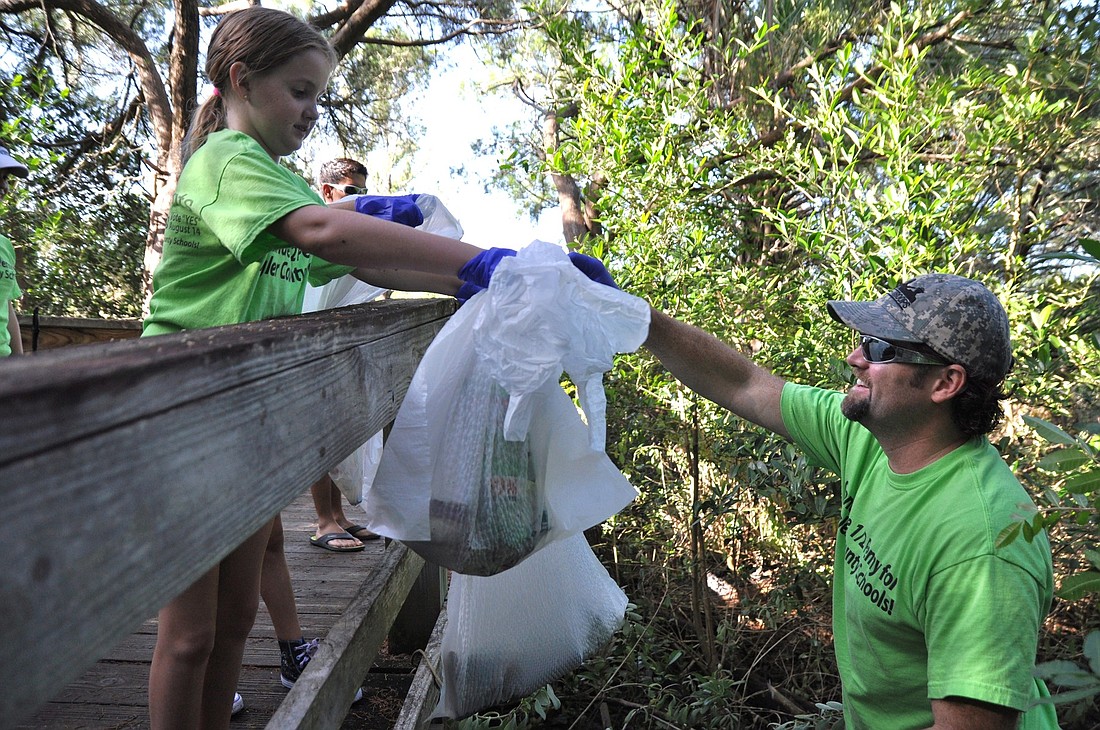 Jesalyn Evans, 9, assists her dad, Martin Evans, at the cleanup.