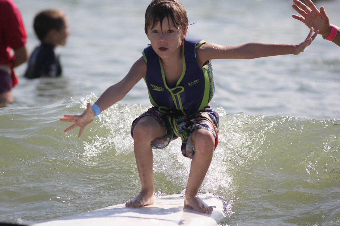 Ian Conway, 5, surfs for the first time during the Surfers for Autism event.