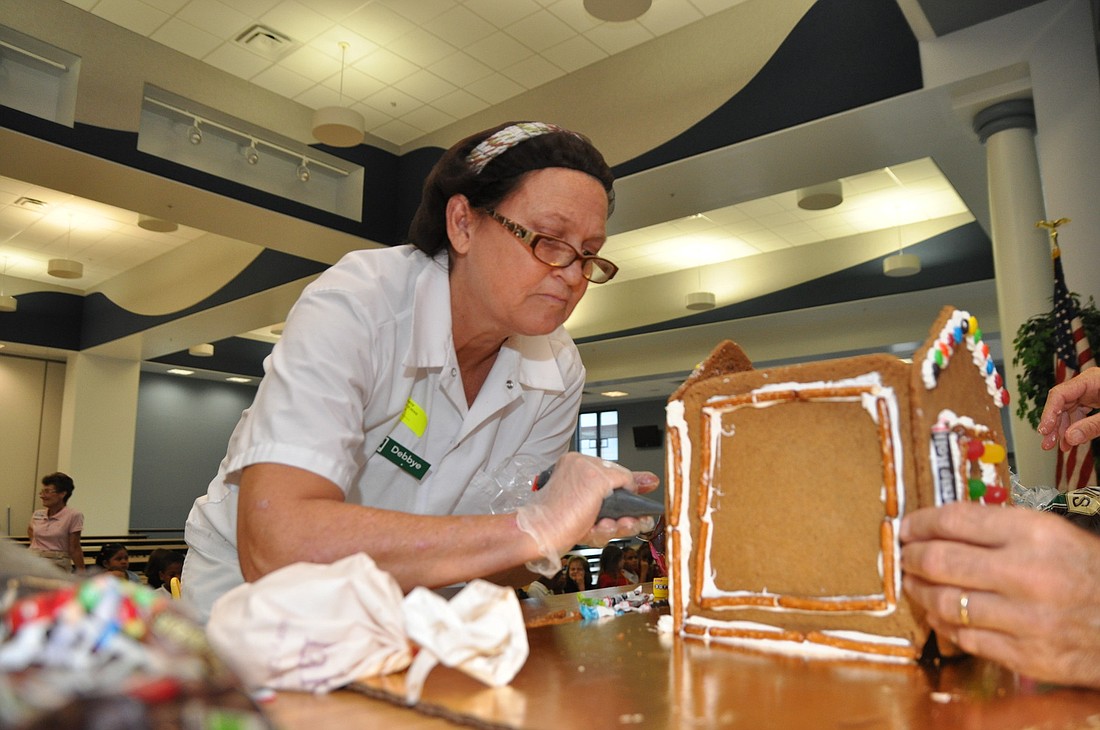 Debbye Faison, of Publix, creates a gingerbread house for the kindergartners.