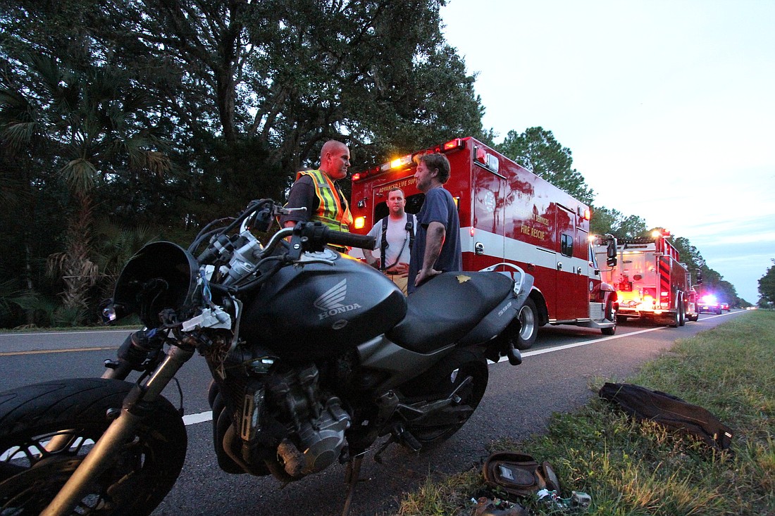 Flagler County Paramedic Ivan Grant questions a motorcycle crash patient Friday, Sept. 14, on State Road 11.