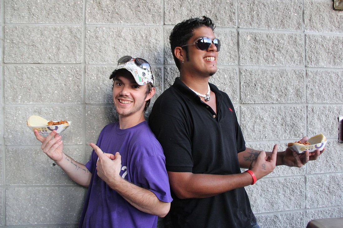 David Stewart and Christian Arzola-Lopez man the WoodyÃ¢â‚¬â„¢s BBQ station Saturday night. Joe Rizzo, owner of the restaurant, donated food to raise money for the Education Foundation's Take Stock in Children scholarship program.