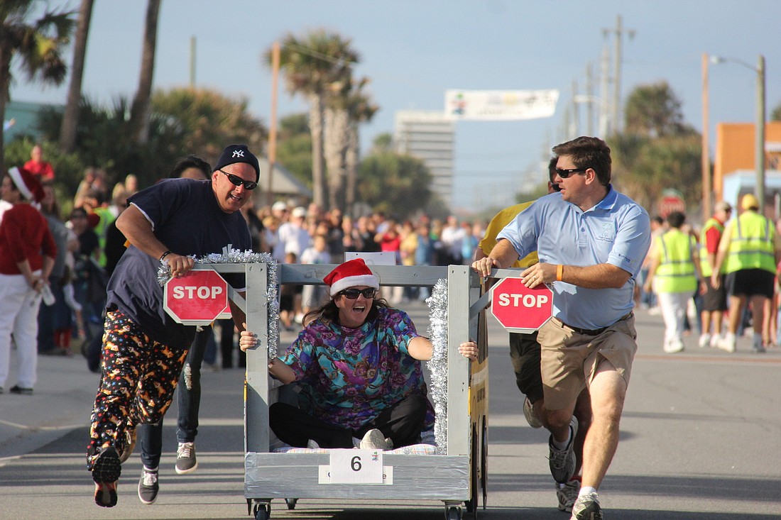 Mike DÃ¢â‚¬â„¢Ascheberg, Colleen Conklin and Trevor Tucker race down the street with their school-bus bed representing Flagler County Schools in the 2011 Bed Race. FILE PHOTO BY SHANNA FORTIER