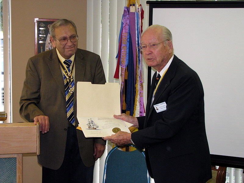 Raymond L. Thompson shows off his certificate, with Ted St. Pierre in the background.