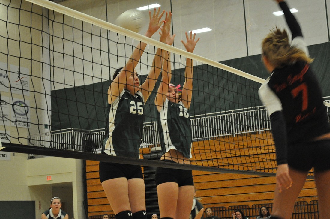 Emily Hartley (No. 25) and Emily Turner (No. 16) attempt a block at the net. ANDREW O'BRIEN