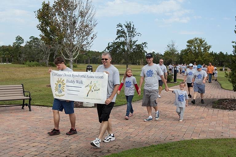 Ryan Popp and Don Wilburn carry the banner at the beginning of the Buddy Walk. Behind them are James, Lana and Zaid Evensen.