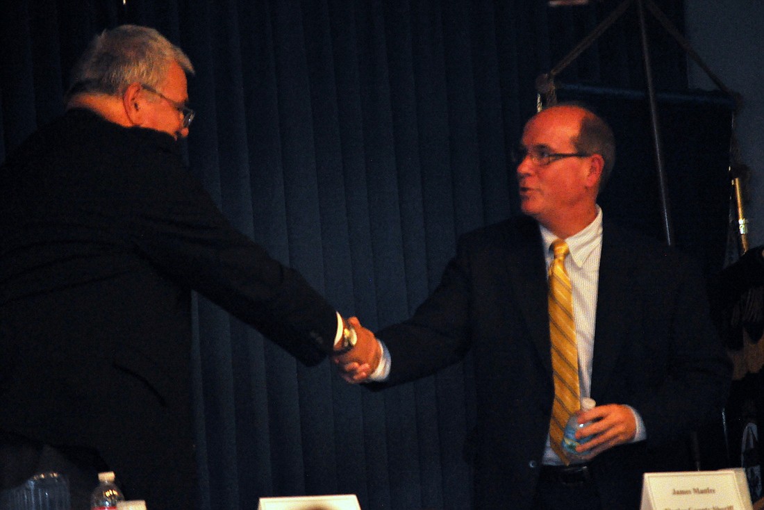 Flagler County Sheriff Donald Fleming shakes hands with challenger Jim Manfre Wednesday night after the Flagler Votes forum.